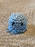 Cute crochet octopus on beige surface