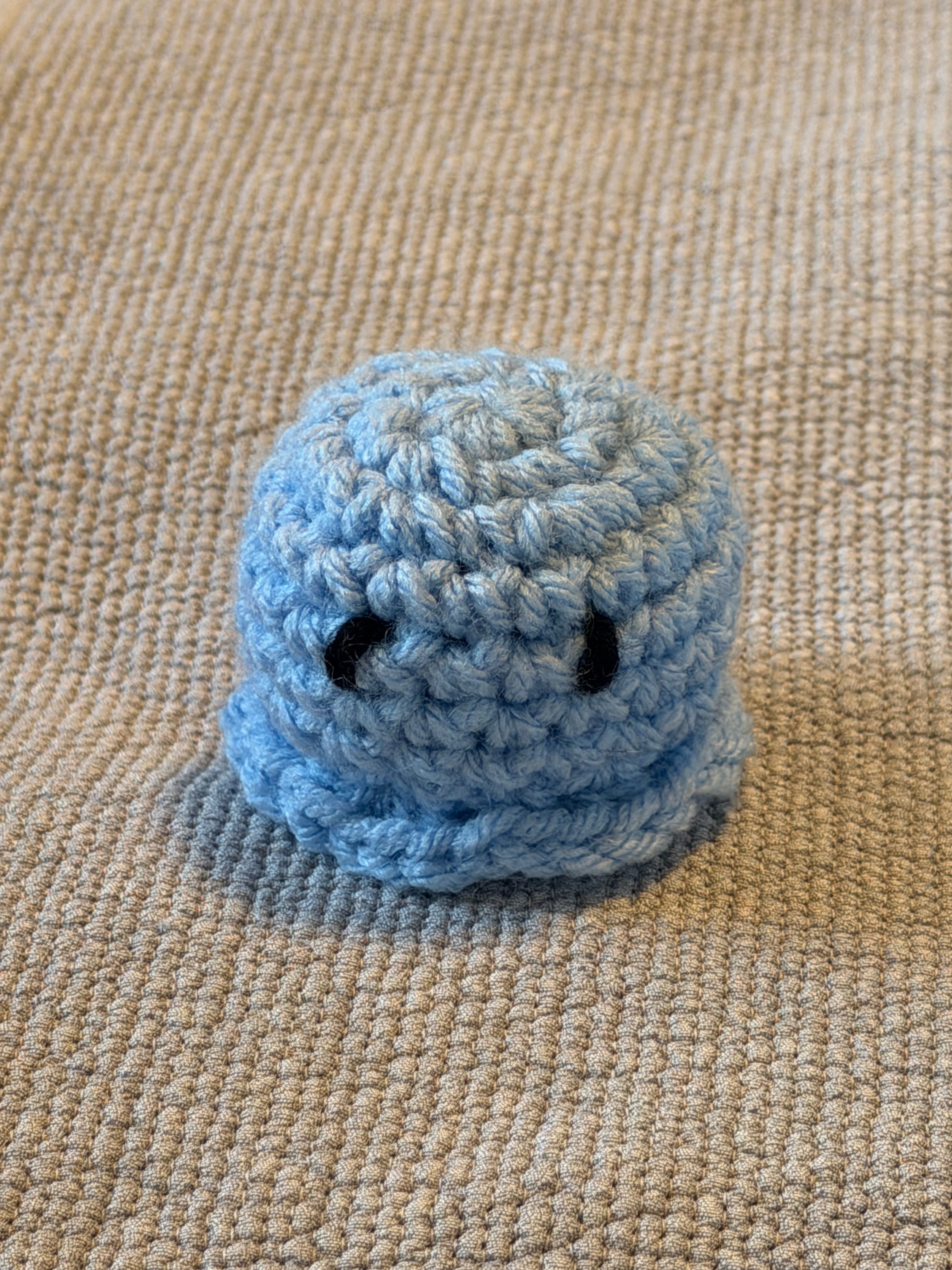 Cute crochet octopus on beige surface